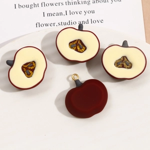 Detail view of dark red resin apple slice pendants with gold glitter accents