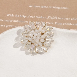 Detailed close-up of handmade woven flower earring with crystal water drop beads