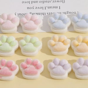 Macro view of plush cat paw DIY resin charms in pastel colors with white bases
