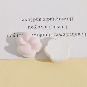 Macro detail of plush pink cat paw resin charms showing soft flocked texture for DIY crafts