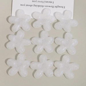 Vue détaillée de neuf fleurs en résine translucide avec paillettes arc-en-ciel pour bricolage
