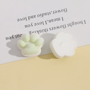 Detail of plush cat paw DIY resin accessory with light green flocking and white base