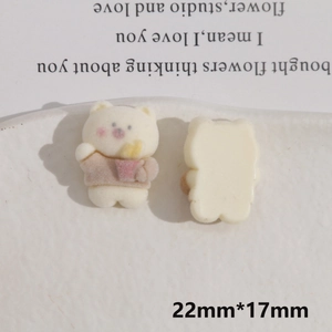 Macro shot showing front and back of cartoon bear resin charms with flocked texture
