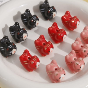 Macroshot van schattige cartoon keramische kattenkralen met gaten voor DIY-sieraden