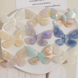 Macro view of gradient acetate butterfly charms in nine pastel colors for hair accessories
