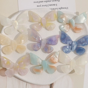 Detailed set of 9 gradient color acetate butterfly hair accessories on a display plate