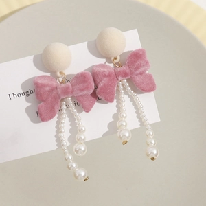 Elegant pink velvet bow earrings with long white pearl tassels and plush round stud detail