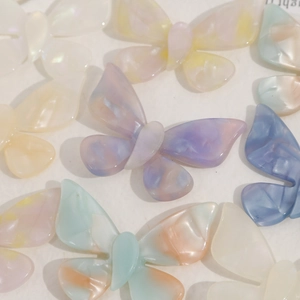 Macro shot of colorful marble-textured acetate butterfly charms for DIY hair accessories