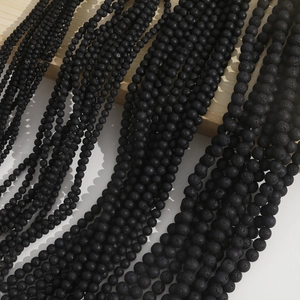 Natural black lava stone beads in multiple sizes for DIY jewelry making on wood stand