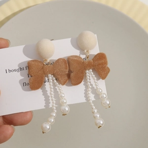 Long drop earrings with plush balls, flocking bows and imitation pearls on a card