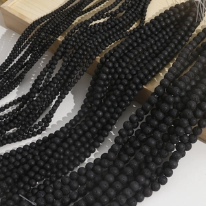 Detailed macro view of black volcanic lava stone beads in various sizes for DIY jewelry