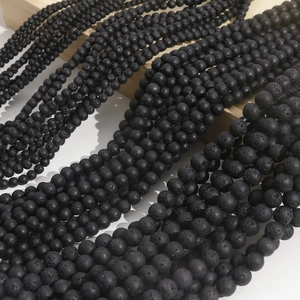 Macro view of matte black volcanic lava rock beads in multiple sizes for DIY jewelry