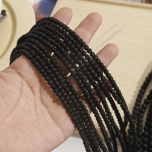 Close-up of black lava stone beads with natural honeycomb texture for DIY jewelry making