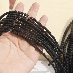 Close-up of matte black lava stone beads showing natural porous texture for DIY jewelry