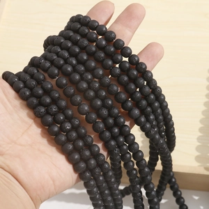 Macro shot of natural black volcanic lava stone beads with porous matte texture for jewelry