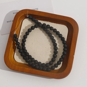 Detailed macro view of natural porous black lava stone beads for DIY jewelry making