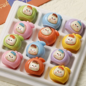 Macro shot of twelve assorted colorful resin fruit doll charms arranged in a grid tray