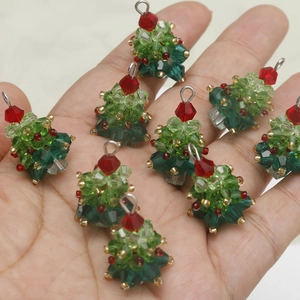 Nahaufnahme von handgefertigten Weihnachtsbaum-Anhängern aus bunten Perlen in der Hand