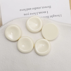 Vista de cinco colgantes redondos de resina crema para joyería DIY y accesorios de pelo
