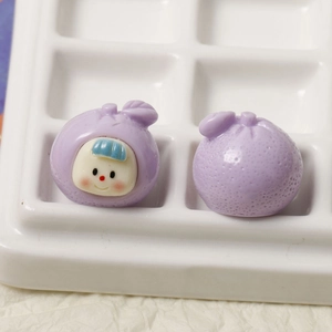 Macro detail of two purple 3D cartoon fruit resin charms with cute smiling faces for DIY