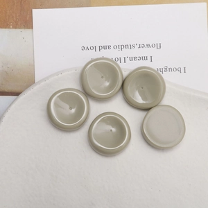 Primer plano de cinco colgantes redondos de resina verde salvia para joyería hecha a mano