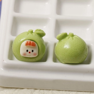 Macro shot of cute green fruit baby resin charms with detailed peel texture for DIY