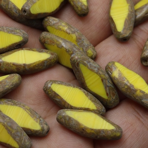 Macro shot of vintage faceted oval glass beads with brown texture and yellow center
