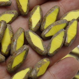 Detailed macro of oval Czech glass beads for DIY jewelry making in a hand palm