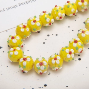 Macro view of yellow floral glass beads for DIY jewelry making and handmade crafts