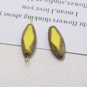 Macro shot of oval faceted glass beads with yellow centers and green mottled textures