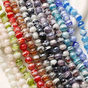 Dettaglio macro di perle di vetro colorate da 12mm con trama marmorea per gioielli fai-da-te