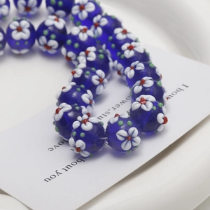 Macro shot of handmade blue lampwork flower beads for DIY jewelry and necklaces