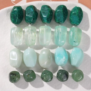 Macro shot of assorted green acrylic beads with gold foil flakes for DIY jewelry making