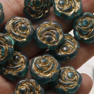 Macro detail of teal Czech glass rose beads with gold accents for DIY jewelry making