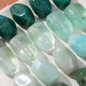 Detailed macro view of assorted green acrylic beads with glitter for DIY jewelry making