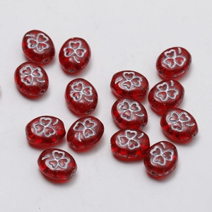 Macro detail of red vintage glass oval beads with silver clover pattern for DIY jewelry
