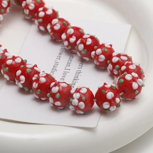 Close-up of handmade red glass flower beads with white petal patterns for DIY jewelry