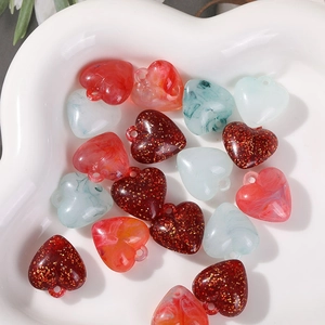 Macro detail of marble pattern and glitter acrylic heart beads for DIY jewelry making