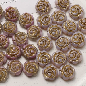 Macro shot of gradient light purple glass rose beads with gold edges on white plate