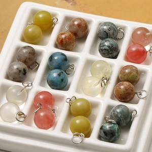 Macro view of assorted 12mm natural stone round pendants with silver jewelry loops