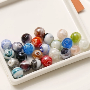 Dettaglio di perle di vetro a strisce colorate irregolari da 12 mm con fori centrali
