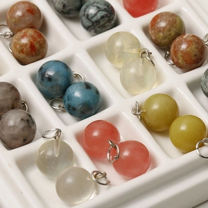 Macro shot of 12mm colorful speckled natural stone charms with metal rings for DIY jewelry