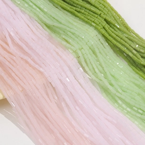 Dettaglio macro di perline di vetro sfaccettate rosa e verdi da 5x3mm per gioielli fai da te
