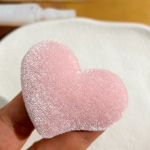 Macro shot of pink plush heart accessory with glitter texture for DIY hair clips