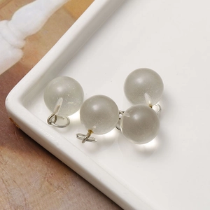 Close-up of four 12mm frosted translucent stone charms with silver metal rings for DIY
