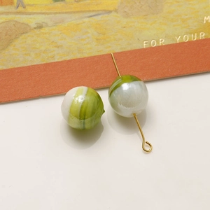 Dettaglio macro di perle in vetro marmorizzato verde e bianco da 12mm per gioielli fai da te