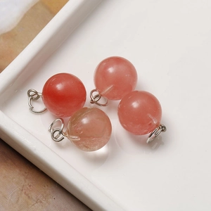 Detail of four 12mm strawberry quartz round stone pendants with silver jump rings