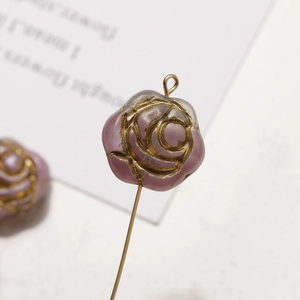 Macro shot of gradient purple glass rose beads with gold embossed lines for jewelry DIY