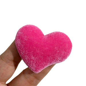 Handheld view of a plush rose pink heart-shaped velvet ornament for DIY hair accessories