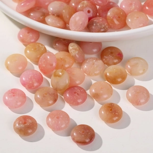 Pink gradient acrylic rondelle beads for DIY jewelry making on white ceramic plate